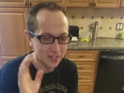 Ian Petrella is sitting in his kitchen.